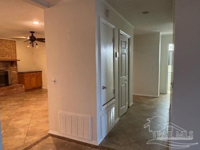 hallway featuring a textured ceiling and light tile patterned floors