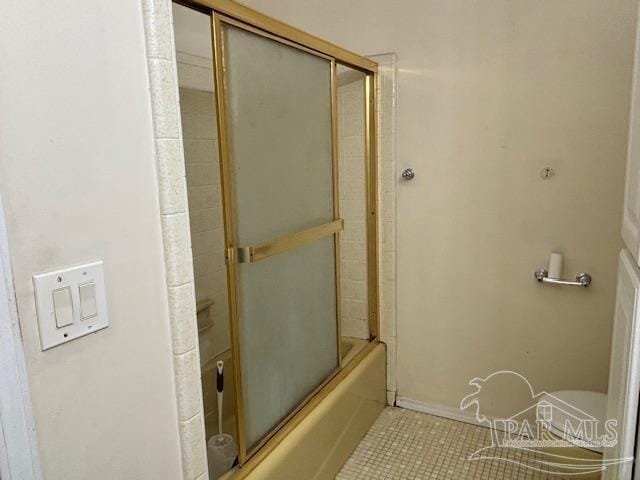 bathroom featuring bath / shower combo with glass door and tile patterned flooring