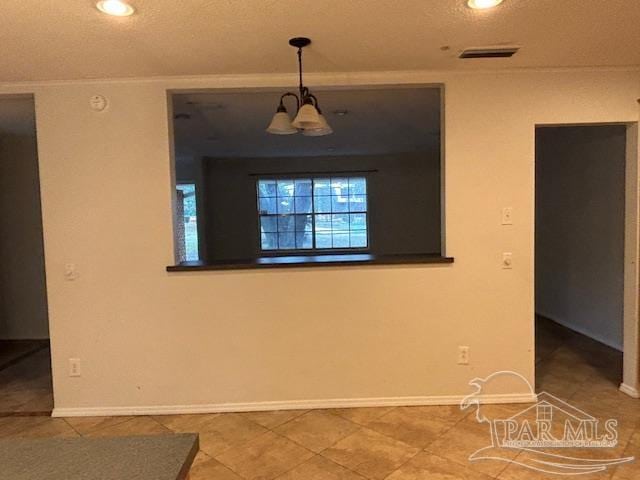 spare room with a textured ceiling and tile patterned floors