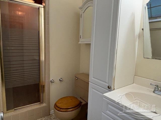 bathroom featuring sink, toilet, and a shower with door