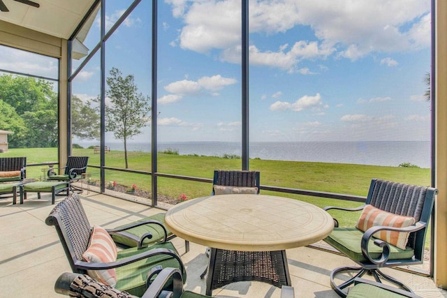 sunroom featuring a water view