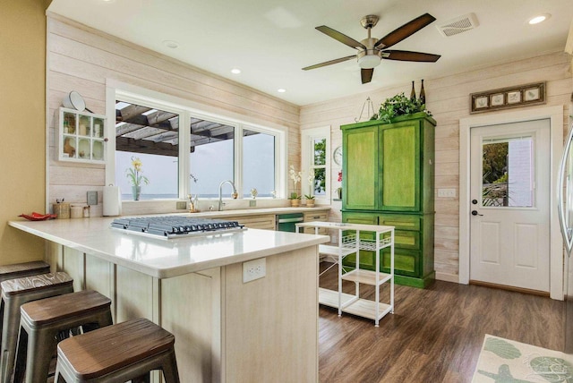 kitchen with a healthy amount of sunlight, wood walls, visible vents, and stainless steel gas stovetop