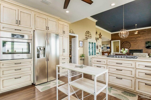 kitchen featuring cream cabinetry, appliances with stainless steel finishes, wood finished floors, and visible vents