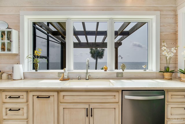 kitchen featuring dishwasher, a sink, light brown cabinets, and a healthy amount of sunlight