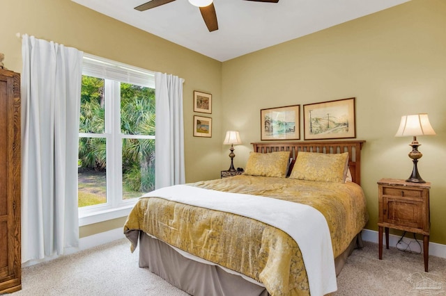 bedroom with light carpet, ceiling fan, and baseboards