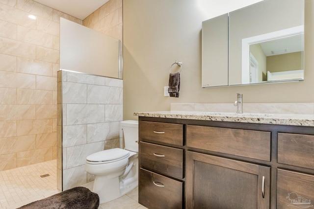 bathroom with a walk in shower, toilet, visible vents, vanity, and tile patterned floors