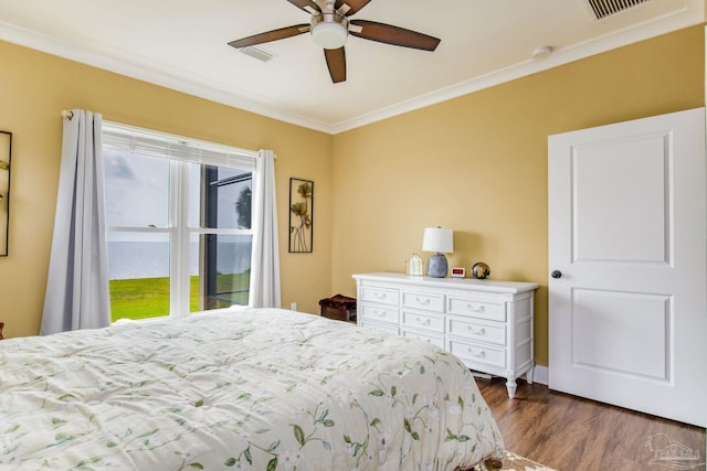 bedroom with dark wood-style floors, visible vents, ornamental molding, and a ceiling fan