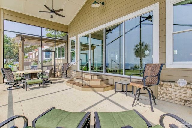 sunroom with vaulted ceiling and a ceiling fan