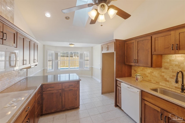 kitchen featuring decorative backsplash, white appliances, lofted ceiling, and sink