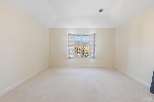 carpeted spare room featuring vaulted ceiling