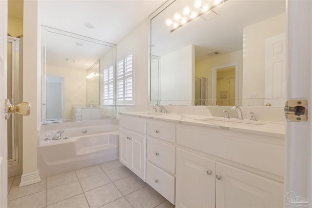 bathroom with tile patterned floors, vanity, and a tub to relax in