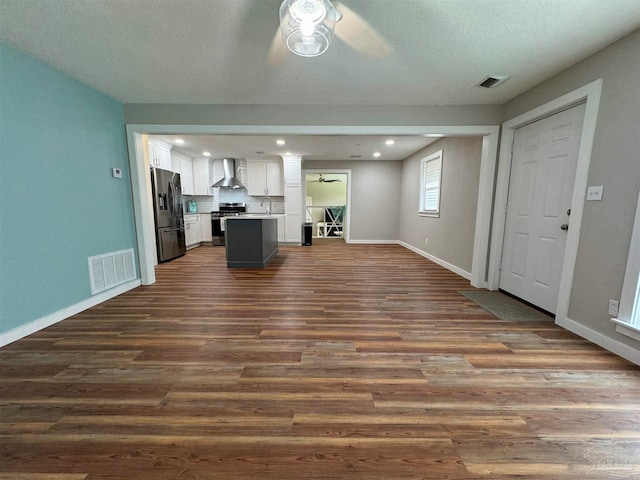 unfurnished living room featuring ceiling fan, dark wood-type flooring, and sink