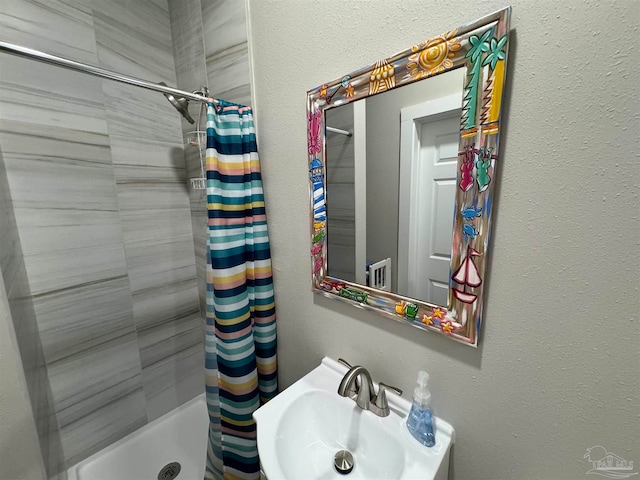 bathroom featuring curtained shower and sink