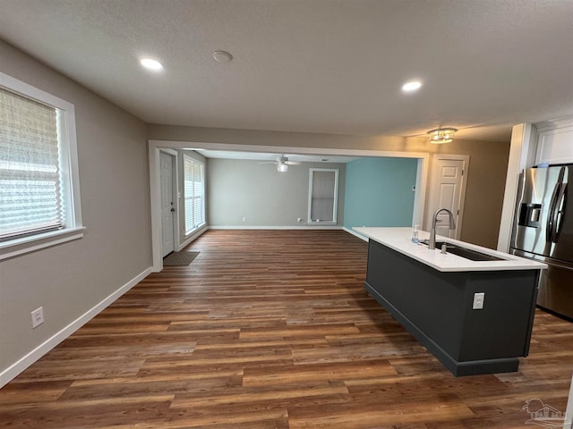 kitchen with an island with sink, dark hardwood / wood-style floors, sink, and stainless steel fridge with ice dispenser