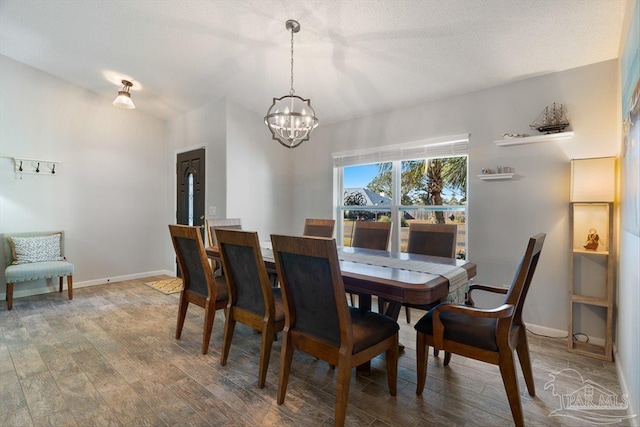 dining room with hardwood / wood-style flooring and a chandelier