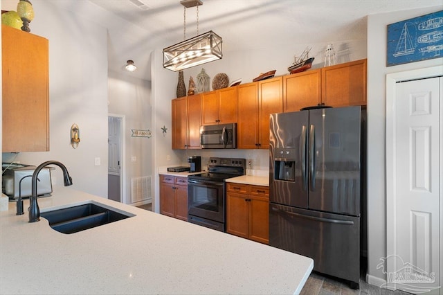 kitchen featuring stainless steel appliances, vaulted ceiling, hanging light fixtures, and sink