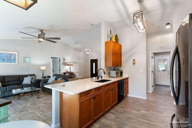 kitchen with pendant lighting, sink, lofted ceiling, black appliances, and kitchen peninsula