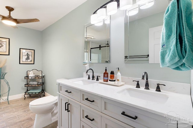 bathroom with vanity, ceiling fan, a shower with door, and toilet