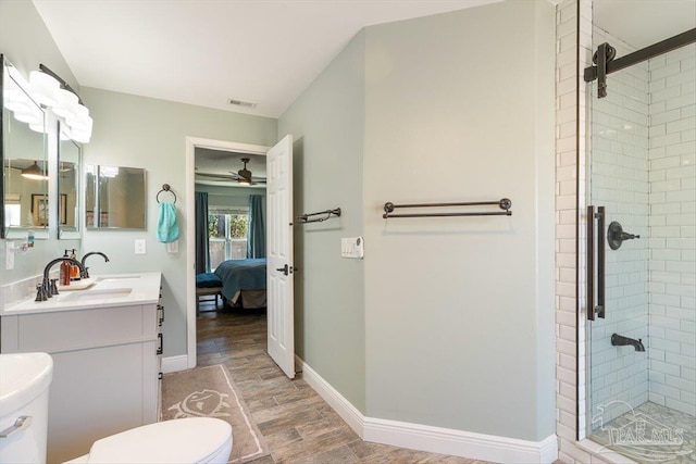 bathroom featuring vanity, a shower with shower door, and toilet