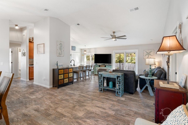 living room with lofted ceiling, dark wood-type flooring, and ceiling fan