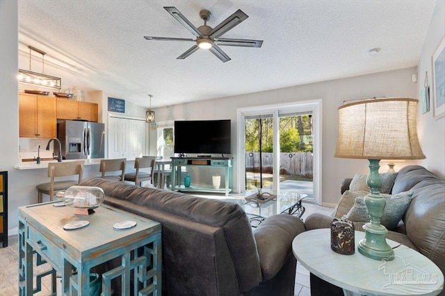 living room with ceiling fan, lofted ceiling, and a textured ceiling