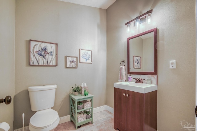 bathroom with toilet, tile patterned floors, and vanity