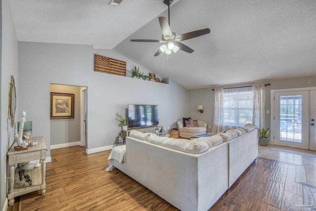 living room featuring ceiling fan, lofted ceiling, hardwood / wood-style floors, a textured ceiling, and french doors