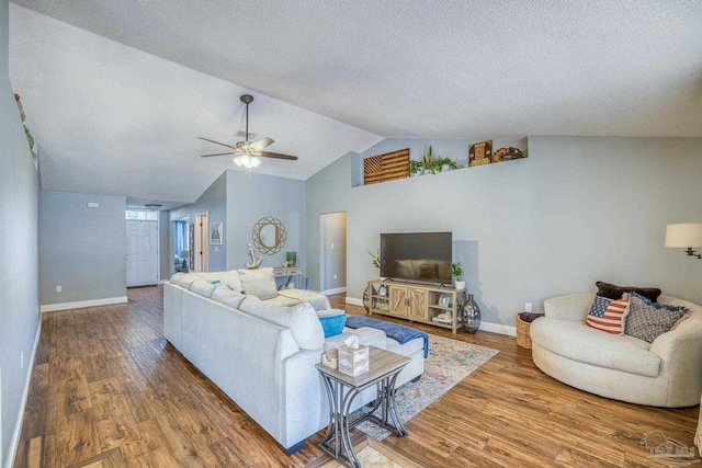 living room with hardwood / wood-style flooring, lofted ceiling, and ceiling fan