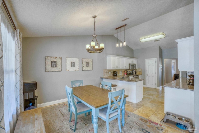 dining area with vaulted ceiling, an inviting chandelier, a textured ceiling, and sink