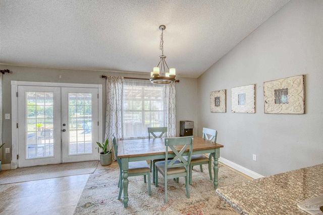 tiled dining area featuring vaulted ceiling, a textured ceiling, french doors, and a notable chandelier