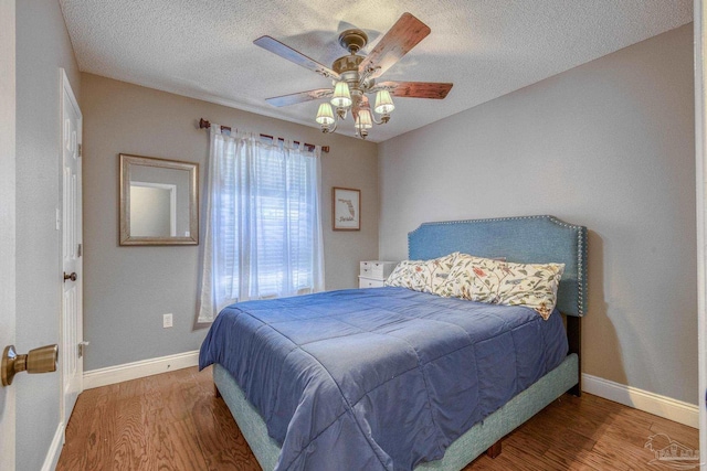 bedroom featuring ceiling fan, a textured ceiling, and hardwood / wood-style floors