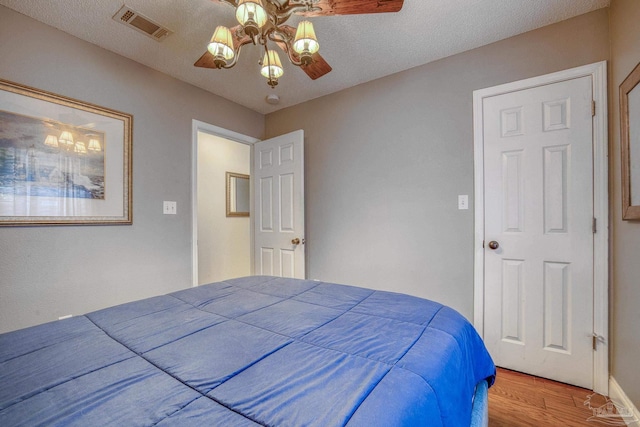 bedroom featuring ceiling fan, a textured ceiling, and hardwood / wood-style flooring