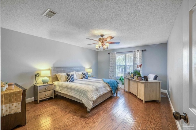 bedroom with a textured ceiling, ceiling fan, and hardwood / wood-style floors