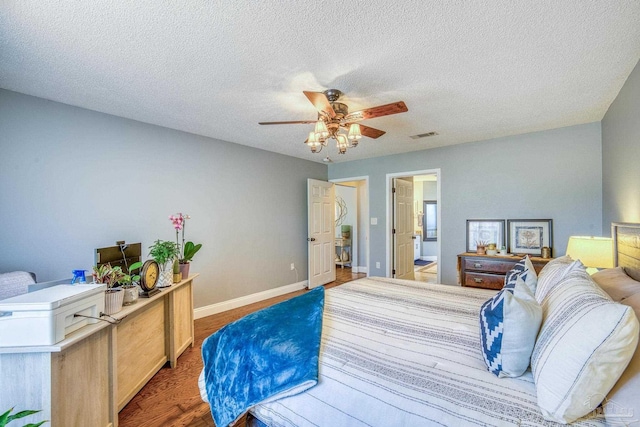 bedroom featuring ceiling fan, dark hardwood / wood-style flooring, ensuite bathroom, and a textured ceiling