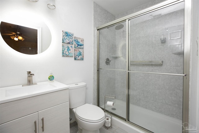 bathroom featuring toilet, an enclosed shower, and vanity