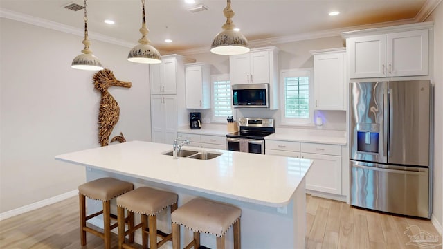 kitchen featuring visible vents, ornamental molding, appliances with stainless steel finishes, light wood-style floors, and a sink