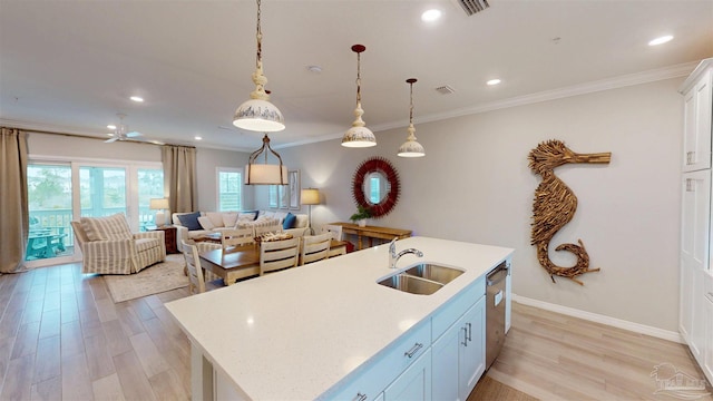 kitchen featuring light wood finished floors, dishwasher, light countertops, and a sink