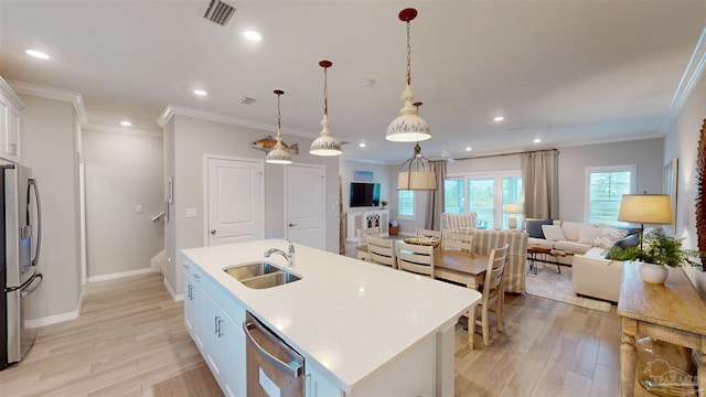 kitchen with visible vents, light wood-style flooring, an island with sink, stainless steel appliances, and a sink