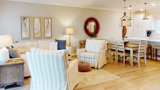 living room with recessed lighting, light wood-type flooring, and crown molding