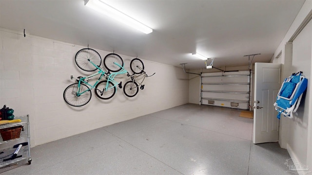 garage with a garage door opener and concrete block wall