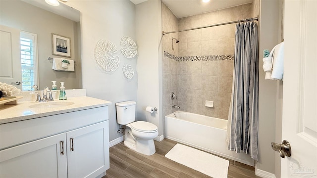 bathroom with shower / bath combo with shower curtain, toilet, wood finished floors, and vanity