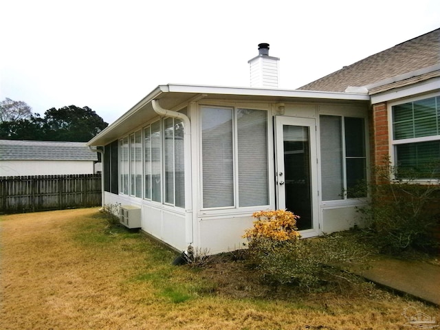 view of property exterior featuring a lawn and a sunroom