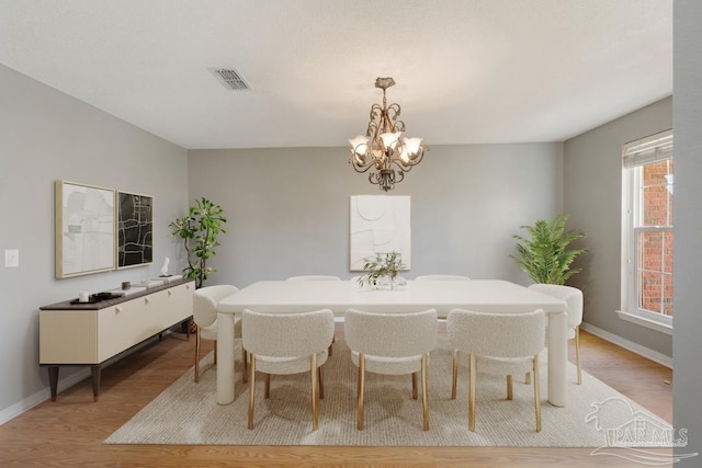 dining room featuring a notable chandelier and light hardwood / wood-style floors