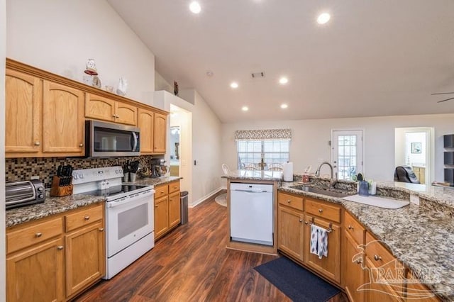 kitchen with vaulted ceiling, sink, light stone countertops, dark wood-type flooring, and white appliances