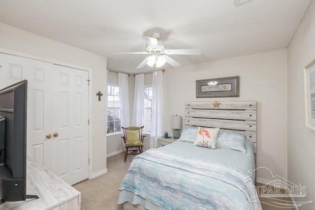 carpeted bedroom with ceiling fan and a closet