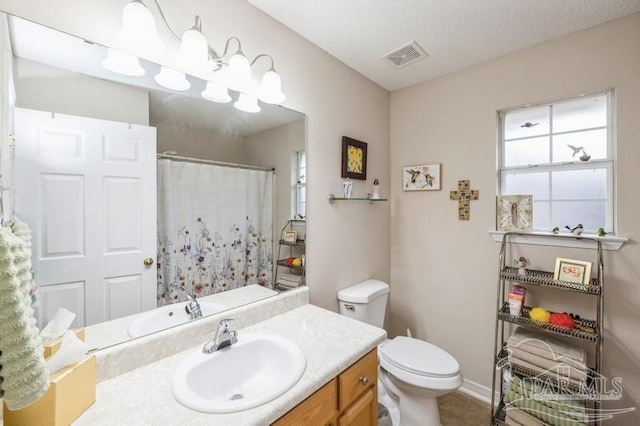 bathroom featuring vanity, a textured ceiling, and toilet