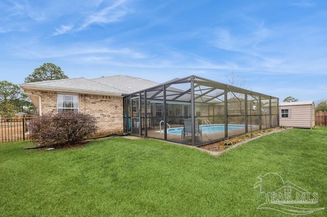 rear view of property with a shed, a fenced in pool, and a yard