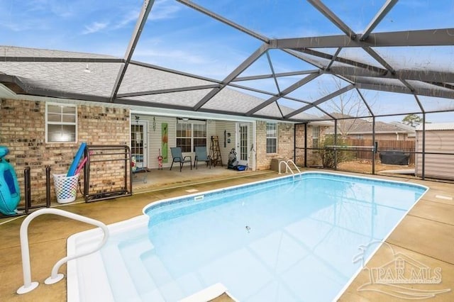 view of swimming pool featuring a patio and a lanai