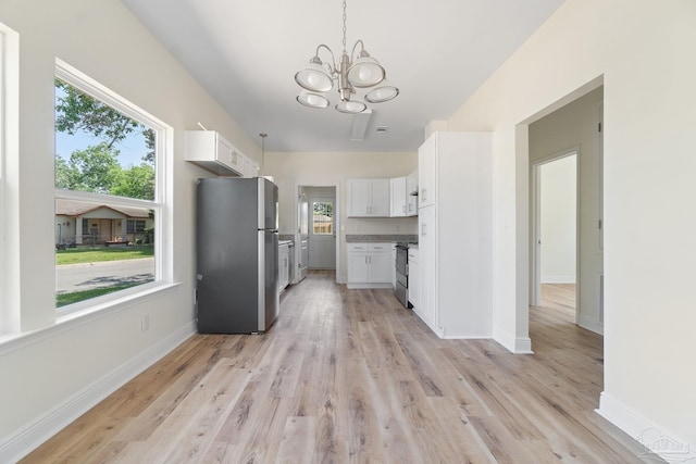 kitchen with a notable chandelier, appliances with stainless steel finishes, baseboards, and white cabinets