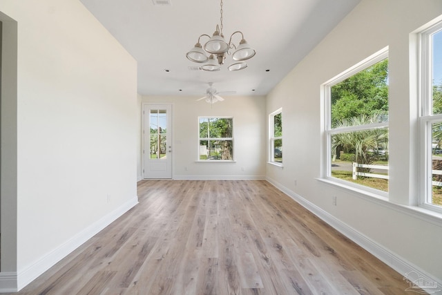 unfurnished room with light wood-type flooring, baseboards, and a chandelier